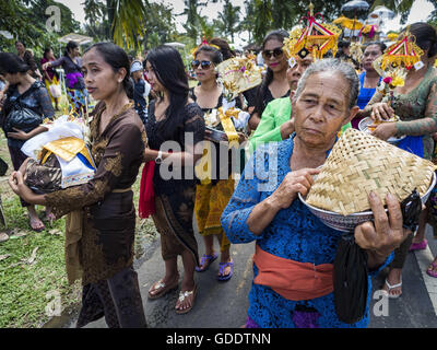 Ubud, Bali, Indonesien. 15. Juli 2016. Frauen tragen Angebote mit den Bildnissen des Friedhofs in Gianyar verbrannt werden. Die meisten Menschen auf Bali sind Hindus. Traditionelle Feuerbestattungen in Bali sind sehr teuer, so dass die Gemeinden in der Regel eine Masse Einäscherung etwa alle fünf Jahre halten. Die meisten der Masse Feuerbestattungen in Bali finden Ende Juni oder Anfang Juli statt. Gianyar, einem kleinen Dorf ca. 30 Minuten von Ubud, statt ihre Dorf breite Feuerbestattung Freitag. Die Gemeinschaft breite Masse Einäscherung in Ubud ist Samstag. © Jack Kurtz/ZUMA Draht/Alamy Live-Nachrichten Stockfoto