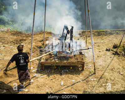 15. Juli 2016 - sorgt für Ubud, Bali, Indonesien - ein Mann, dass der Sarkophag mit das Bildnis des Verstorbenen an die Gemeinschaft breite Feuerbestattung in Gianyar vollständig verbrannt ist. Die meisten Menschen auf Bali sind Hindus. Traditionelle Feuerbestattungen in Bali sind sehr teuer, so dass die Gemeinden in der Regel eine Masse Einäscherung etwa alle fünf Jahre halten. Die meisten der Masse Feuerbestattungen in Bali finden Ende Juni oder Anfang Juli statt. Gianyar, einem kleinen Dorf ca. 30 Minuten von Ubud, statt ihre Dorf breite Feuerbestattung Freitag. Die Gemeinschaft breite Masse Einäscherung in Ubud ist Samstag. (Kredit-Bild: © Jack Kurtz vi Stockfoto