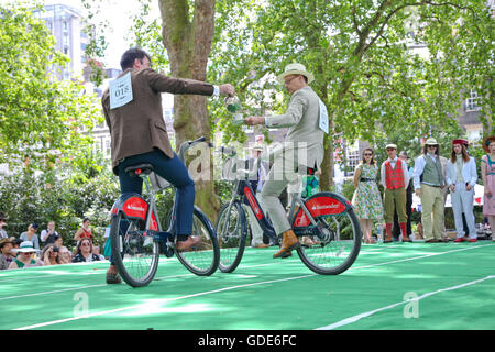 Bedford Square, London, UK. 16. Juli 2016. Der Chap-Olympiade - Teilnehmer in der Tee-Verfolgung. Die Beleuchtung der Olympischen Pipe. Hunderte von modisch gekleidete Teilnehmer und Zuschauer besuchen die Chap-Olympiade am Bedford Square in London feiern Großbritanniens sportliche Ungeschicklichkeit und Exzentrizität mit einer Reihe von Leichtathletik-Veranstaltungen, wo mehr Punkte für Stil, als erste über die Ziellinie vergeben werden. Bildnachweis: Dinendra Haria/Alamy Live-Nachrichten Stockfoto