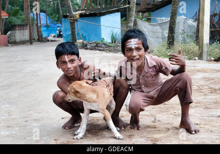 Nicht identifizierte zwei indischen Jungen mit Hund auf der Straße im Fischerdorf. Kovalam. Kerala. Indien Stockfoto