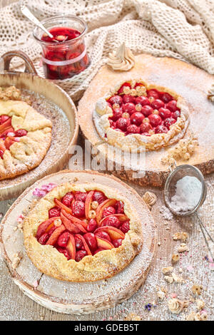 Rustikale Obstkuchen und Meringues, hausgemachtem Gebäck auf Holztisch, Pastell-Farben. Stockfoto
