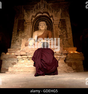 Novize sitzen vor Buddha-Statue in Pagode Bagan, Mandalay, Myanmar Stockfoto