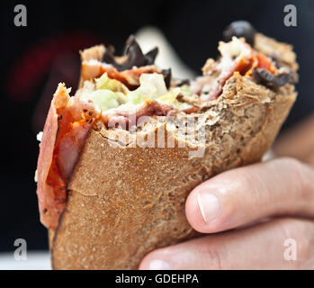 Mannes Hand hält die Hälfte gegessen sandwich Stockfoto