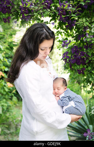 Mutter mit schlafenden Baby im Garten Stockfoto