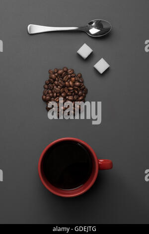 Kaffeetasse mit Kaffeebohnen und Teelöffel mit weißen Würfelzucker Stockfoto