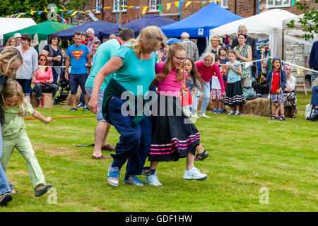 Familien nehmen Teil In einem traditionellen drei Beinen Rennen am Fairwarp Dorffest, Fairwarp, East Sussex, UK Stockfoto