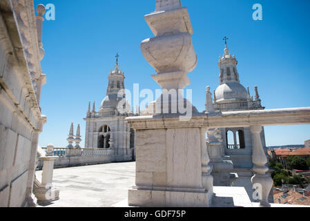 Kloster von São Vicente de fora Dachterrasse Lissabon Portugal // LISSABON, Portugal - das Dach des Klosters von São Vicente de fora bietet einen atemberaubenden Panoramablick auf Lissabons historische Stadtlandschaft. Dieses Kloster aus dem 16. Jahrhundert, das dem Heiligen Vincent gewidmet ist, ist eines der wichtigsten religiösen Denkmäler der Stadt und verfügt über eine beeindruckende barocke Fassade. Der Klosterkomplex beherbergt das pantheon der Braganza-Monarchen, Portugals letzte königliche Dynastie. Von diesem erhöhten Aussichtspunkt aus können Besucher Lissabons charakteristische Terrakotta-Dächer, den Tejo und zahlreiche historische Landme beobachten Stockfoto