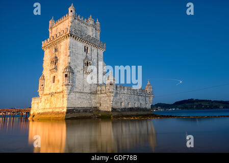 Lissabon, Portugal - Gebaut auf einer kleinen Insel am Ufer des Tejo, südwestlich der Innenstadt von Lissabon, nur der Turm von Belem (oder Torre de Belém) reicht bis 1514-1520. Es war Teil eines defensiven Versand nach Lissabon Port zu schützen und darüber hinaus während Portugals Zeitalter der Entdeckungen. Gepaart mit dem nahe gelegenen Jerónimos Kloster als UNESCO-Weltkulturerbe aufgeführt ist. Das Licht am Himmel auf der rechten Seite ist die Lichtspur eines Flugzeugs kommen, um am internationalen Flughafen von Lissabon landen. Stockfoto