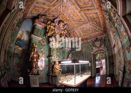 Museu Militar Prunkvoller Innenraum Militäranzeigen Lissabon Portugal | LISBON, Portugal — Militäranzeigen säumen die Wände eines prunkvoll geschmückten Raumes im Museu Militar in der Nähe des Bahnhofs Santa Apolónia in Lissabon, wo goldverzierte Oberflächen und bemalte Decken einen reichen Hintergrund für die Sammlungen bilden. Die prächtigen Innenräume des Gebäudes wurden von führenden portugiesischen Künstlern geschaffen — unter ihnen Columbano Bordalo Pinheiro, José Malhoa und Adriano Sousa Lopes — im Rahmen eines Gedenkschemas, das Deckengemälde mit Schlachtszenen und sechsundzwanzig Azulejo-Paneele im Innenhof umfasst Stockfoto