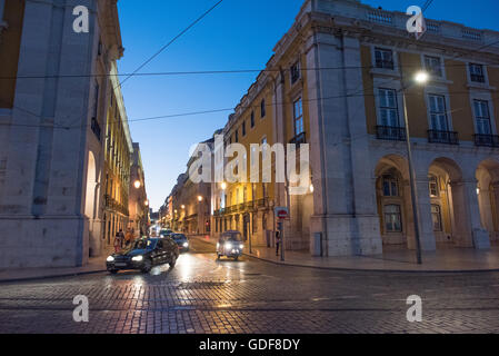 LISSABON, Portugal – Eine charmante Seitenstraße zweigt vom Prac do Comércio (Handelsplatz) im historischen Stadtteil Baixa ab. Die Straße zeigt typische Architektur im pombalinischen Stil mit ihren einheitlichen Fassaden, schmiedeeisernen Balkonen und gefliesten Wänden. Dieses Gittermuster, das charakteristisch für die Stadtplanung des Gebiets aus dem 18. Jahrhundert ist, bietet einen Einblick in den Wiederaufbau von Lissabon nach dem Erdbeben und das tägliche Stadtleben. Stockfoto