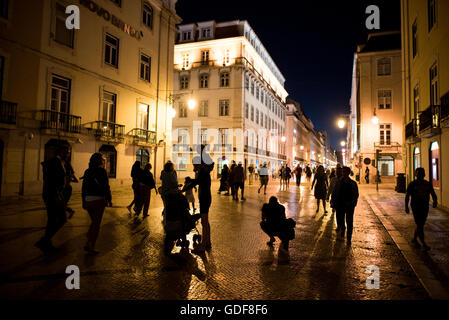 Rua Augusta Fußgängerzone Lissabon Portugal // LISSABON, Portugal – die Rua Augusta, eine Fußgängerzone im historischen Zentrum von Lissabon, wird abends von kunstvollen Straßenlaternen beleuchtet. Die Durchgangsstraße verbindet den Fluss Tejo mit dem Hauptgeschäftsviertel der Stadt und dient als primäre Fußgängerroute durch das Stadtviertel Baixa. Straßenlaternen säumen den kopfsteingepflasterten Fußweg, der von traditioneller portugiesischer Architektur flankiert wird und Geschäfte und Cafés beherbergt. Rua Augusta ist Teil des Wiederaufbaus der Innenstadt von Lissabon nach dem Erdbeben von 1755 in Pombaline. Das boul Stockfoto