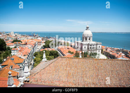 Kloster von São Vicente de fora Lissabon Portugal // LISSABON, Portugal - das Dach des Klosters von São Vicente de fora bietet einen atemberaubenden Panoramablick auf Lissabons historische Stadtlandschaft und den Tejo. Dieses Kloster aus dem 16. Jahrhundert, das dem Heiligen Vincent gewidmet ist, ist eines der wichtigsten religiösen Denkmäler der Stadt und verfügt über eine beeindruckende barocke Fassade. Von diesem erhöhten Aussichtspunkt aus können Besucher die weite Ausdehnung des Flusses Tejo beobachten, der eine entscheidende Rolle in Portugals maritimer Geschichte und Handel gespielt hat. Die Aussicht umfasst Lissabons charakteristische Terrakotta-Dächer Stockfoto