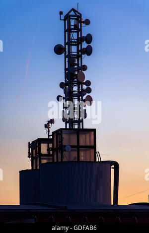 Telekommunikation-Mast mit Mikrowelle Link auf Dach bei Sonnenuntergang Hintergrund. Stockfoto