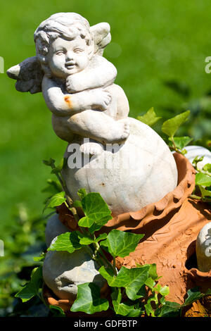 Stein-Putto Figur in einem Garten Stockfoto