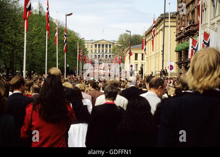 Menschen in Kostümen in die Parade zum Schloss am Ende der Hauptstraße Karl Johan Stockfoto