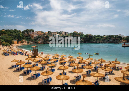 Stroh Sonnenschirme am Strand in Porto Cristo auf Mallorca, Balearen, Spanien Stockfoto