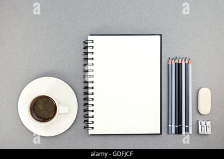 Tasse Kaffee und Notebook mit Zeichenwerkzeugen auf Schreibtisch, Ansicht von oben Stockfoto