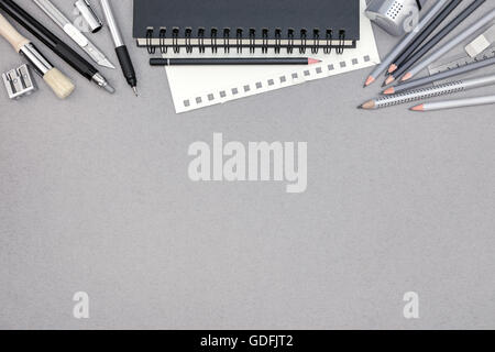 Draufsicht der grauen Büroschreibtisch mit Spiral-Notizbuch und verschiedene Zeichenwerkzeuge Stockfoto