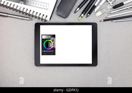Digital-Tablette, Spiral-Notizbuch und verschiedene Zeichenwerkzeuge auf grauen Recyclingpapier Hintergrund Stockfoto