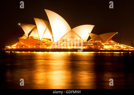 Beleuchtete Sydney Opera House spiegelt sich im Wasser des Hafens. Stockfoto
