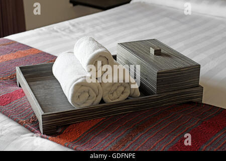 weiße Handtücher gerollt und stapelten in Holztablett Stockfoto