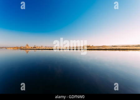 Panorama Sonnenuntergang Sonnenaufgang Sonne steigt über den Fluss. Herbst Frost gefrorenen Fluss mit dünnem Eis bedeckt. Stockfoto