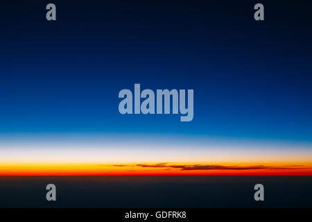 Schönes Panorama des Sonnenuntergangs aus Höhe des Flugzeugs. Dunkle Sonnenaufgang Himmel. Stockfoto
