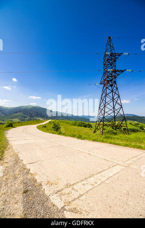 Elektrische Hochspannungsleitungen Turm in der Nähe von der Straße in Bergen Stockfoto