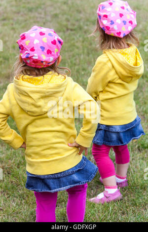 Kinder Zwillinge hinten, Mädchen in den gleichen Outfits die gleiche Kleidung Stockfoto