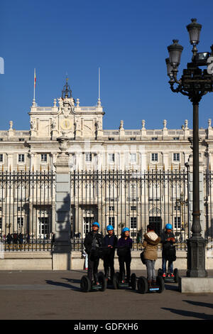 Asiatische Touristen, die den königlichen Palast im Rahmen einer Segway Tour, Plaza De La Armeria, Madrid, Spanien Stockfoto