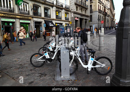 Mann, die Anmietung eines BiciMAD-Elektro-Fahrrads an einer Docking-Station am Plaza Puerta del Sol, Madrid, Spanien Stockfoto