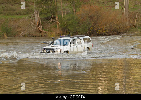 Allrad Fahrzeug mit Bugwelle weißen angeschnittene Ärmel Wasser machen gefährliche Überquerung der überfluteten Fluss in New South Wales zu schaffen. Australien Stockfoto