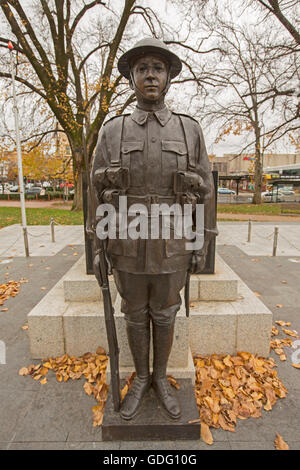 Große, spektakuläre und lebensechte Bronzestatue des Weltkrieges ein Soldat in Uniform an australisches Kriegerdenkmal im Stadtpark Stockfoto