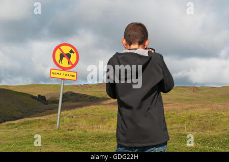 Island: ein Junge nimmt ein Bild des Zeichens Verbot für Hunde im Fluss Tal von Skoga Stockfoto