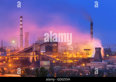 Metallurgische Fabrik in der Nacht. Stahlwerk mit Schornsteinen. Stahlwerke, arbeitet Eisen. Schwerindustrie in Europa. Luftverschmutzung Stockfoto