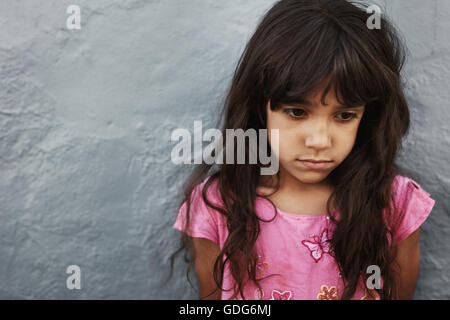 Porträt des unglücklichen Mädchen gegen graue Wand mit textfreiraum hautnah. Junge Mädchen auf der Suche stören. Stockfoto