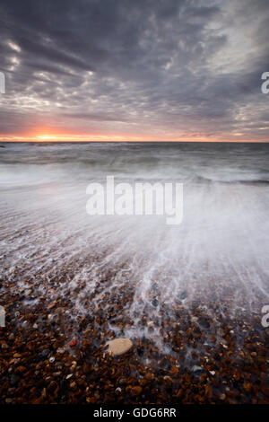 Verschwommene Rückspülung bei der Kiesstrand am Seaton Schleuse, Collywell Bucht Stockfoto