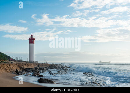 DURBAN, Südafrika - 12. März 2016: Umhlanga Rocks Leuchtturm mit Fischern und Menschen zu Fuß auf der Promenade. Schiff auf der Stockfoto