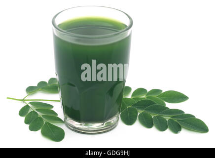 Moringa Blätter mit Extrakt in einem Glas auf weißem Hintergrund Stockfoto