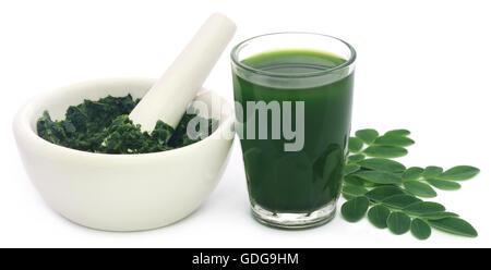 Moringa Blätter mit Extrakt in einem Glas auf weißem Hintergrund Stockfoto