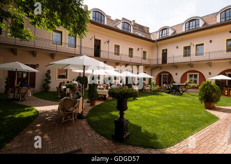 Ein Innenhof eines Hotels, in dem Gäste entweder Erfrischungen oder ein Mittagessen in einem Hotel/Restaurant auf dem Burgberg von Buda, Budapest, Ungarn, genießen können. Stockfoto