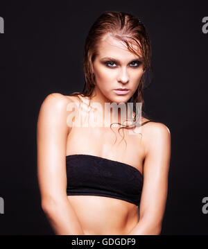 Portrait von junge schöne Frau mit nassen strahlendes Make-up auf schwarzem Hintergrund Stockfoto