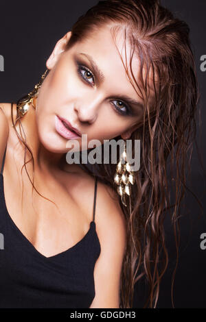 Portrait von junge schöne Frau mit nassen strahlendes Make-up auf schwarzem Hintergrund Stockfoto