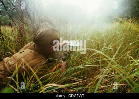 Teryuha, Belarus - 4. Oktober 2015: Unidentified Re Enactor verkleidet als russische Sowjetsoldaten Reload Maschinengewehr Wald Gras Stockfoto