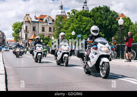 Polnische Polizei Motorrad-Konvoi auf einer Brücke mit Blick auf die alten Stadttürme im Hintergrund. Stockfoto