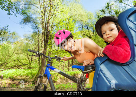 Kleines Mädchen im Fahrradsitz hinter ihrer sportlichen Mutter Stockfoto