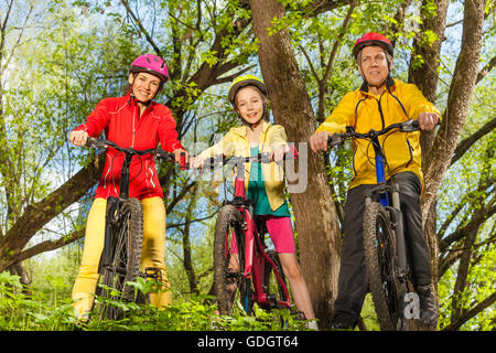 Glücklich sportliche Familie auf dem Fahrrad im sonnigen Wald Stockfoto