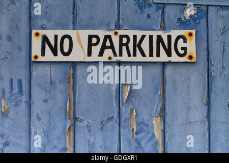 Kein Parkplatz-Schild an einer alten blauen Holztür mit abblätternde Farbe Stockfoto