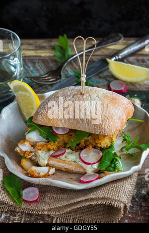 Knusprige hausgemachte Fisch-Burger oder Sandwich mit Salat Stockfoto