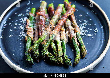 Gegrillter Spargel, eingehüllt in Parma-Schinken mit Parmesan, Salbei und Thymian Stockfoto